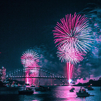 red and blue fireworks over a bridge